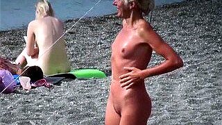 Cute nudist golden-haired with diminutive whoppers sunbathing and flirting on the beach