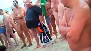 Interracial threesome on a nude beach with lots of spectators